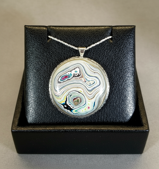 Necklace with a round pendant in a black box on a beige surface